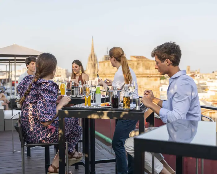Drinks are served in glasses on a table with wine glasses and bottles.