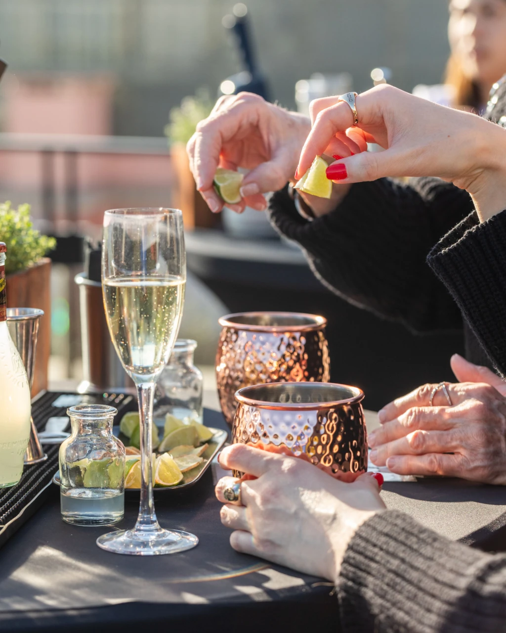 Drinks are served in glasses on a table with wine glasses and bottles.
