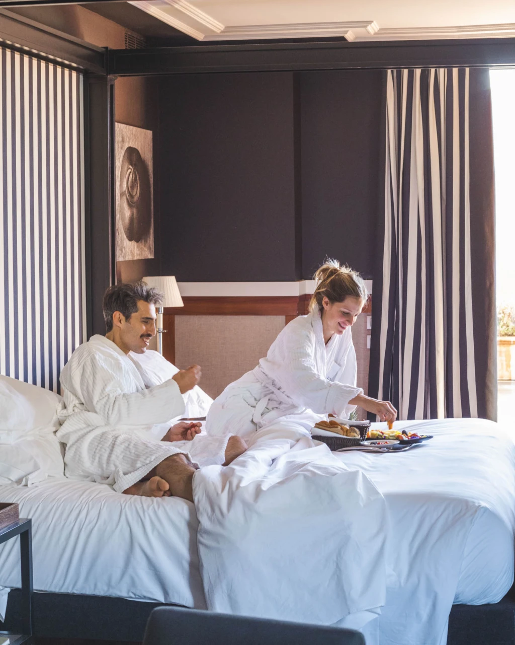 A tray with breakfast, arranged on a bed, creates a cozy and elegant atmosphere for a luxury stay.