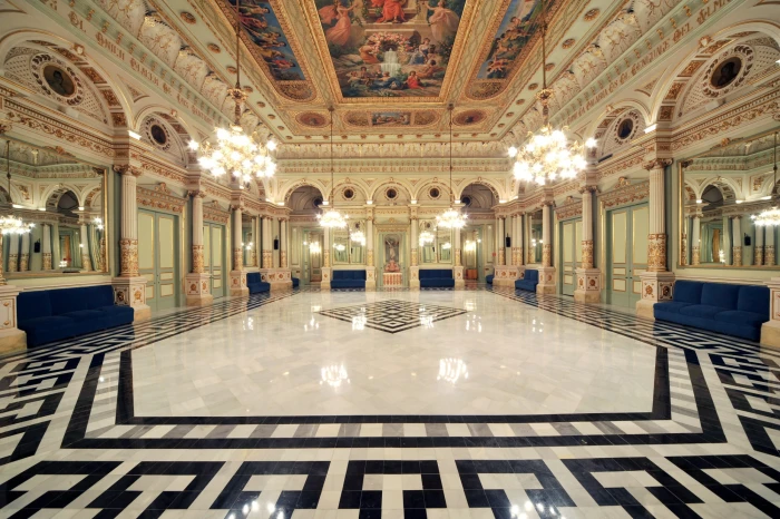 S’hi veu una sala espaiosa amb terra de marbre, llums de sostre i parets amb arcs decoratius.