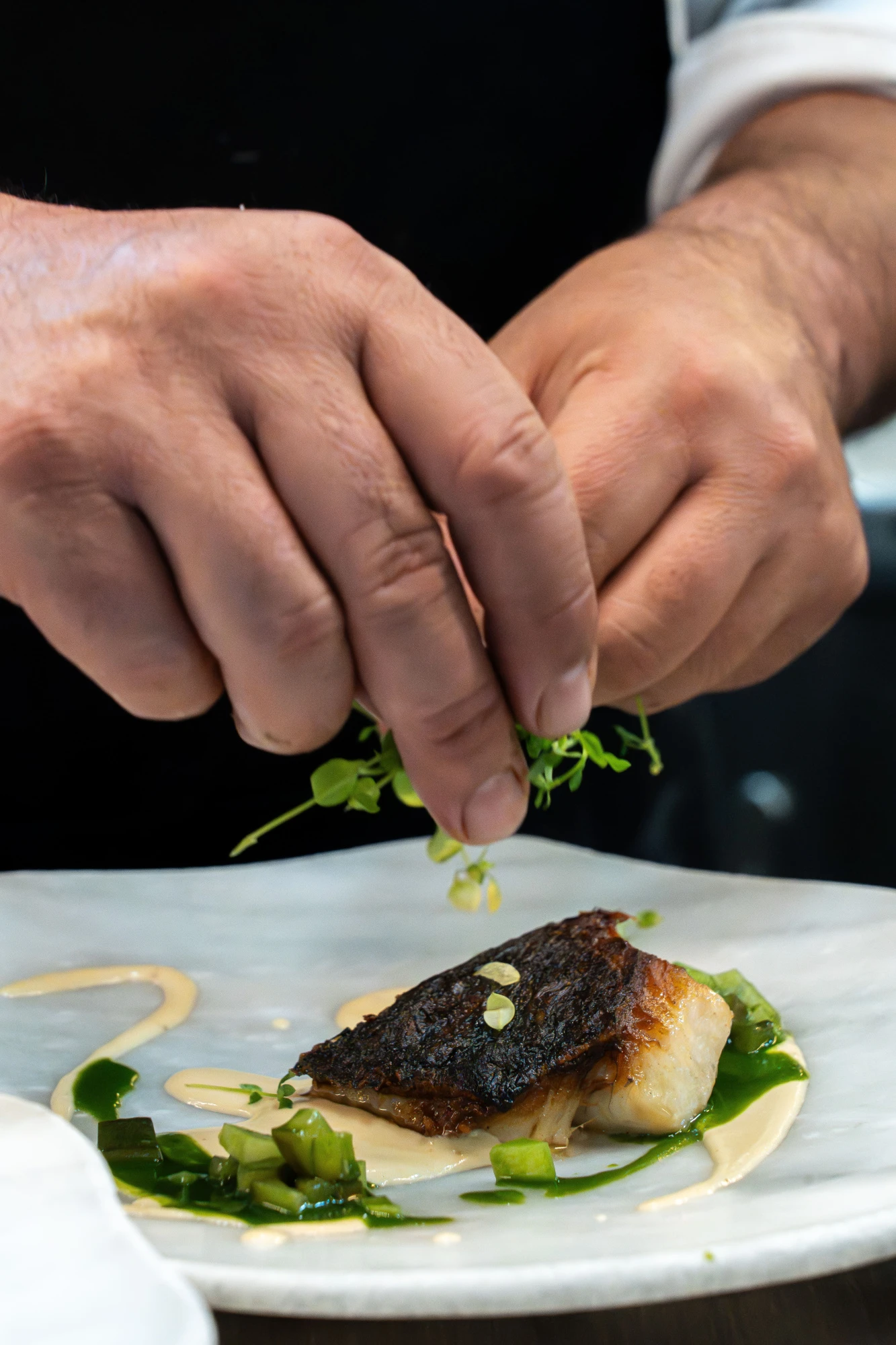La imagen muestra un elegante interior de restaurante con un ambiente sofisticado, destacando detalles de decoración moderna y una iluminación cálida.