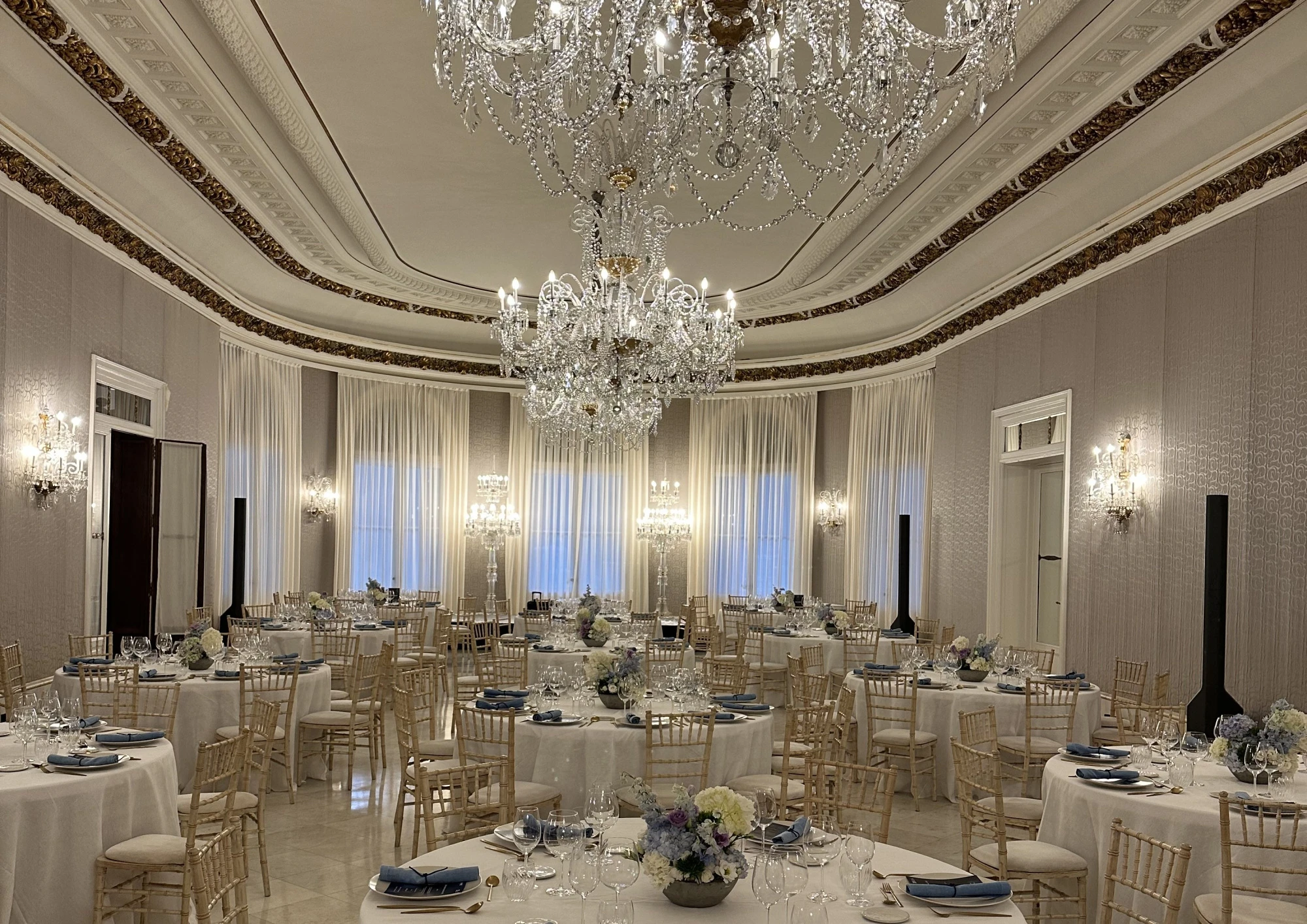 Una vista del interior de un hotel con mobiliario moderno y elegante, destacando una zona de descanso con sillones y mesas en un ambiente luminoso y acogedor.
