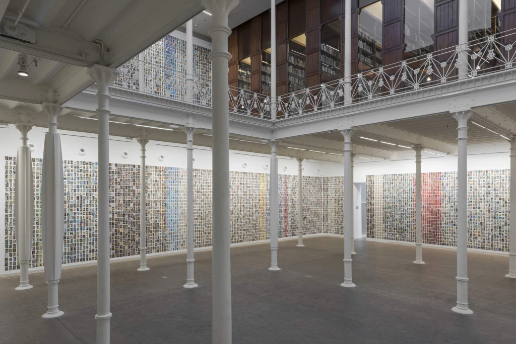 Inner courtyard with white columns and walls covered in colorful mosaics.