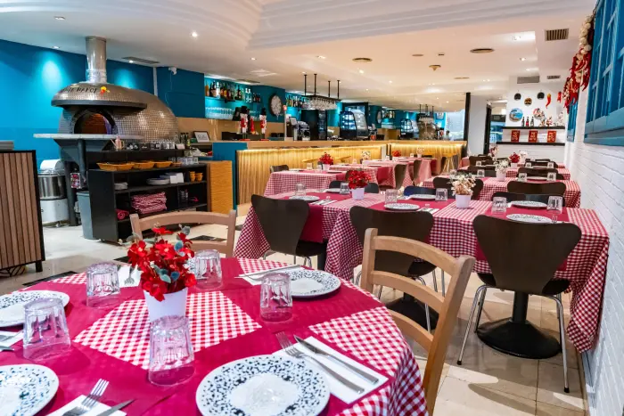 Una fachada moderna de un restaurante o cafetería con un diseño contemporáneo, que presenta una entrada amplia y luminosa, ideal para un ambiente acogedor y elegante.