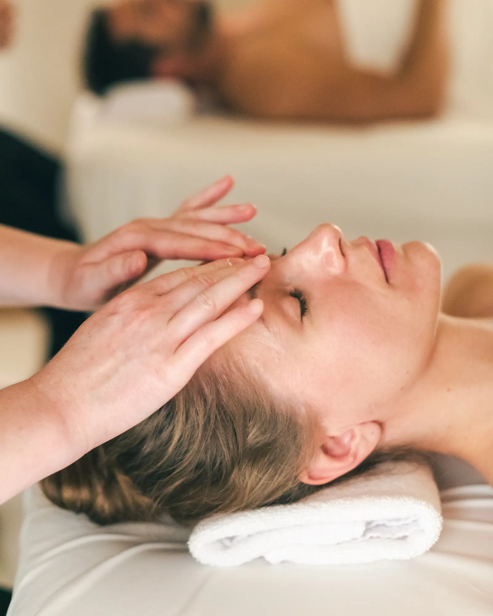 Ein Mädchen erhält in einem Spa eine entspannende Kopfmassage.