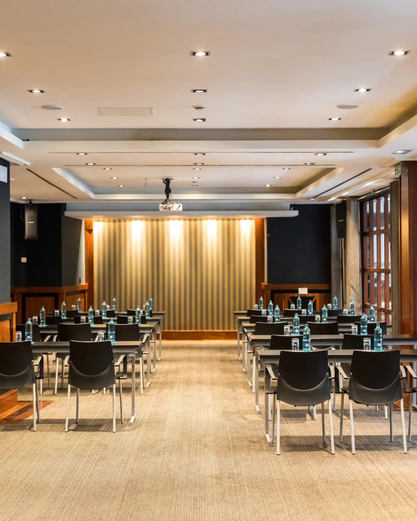 The image shows a meeting room with tables and chairs arranged in rows.