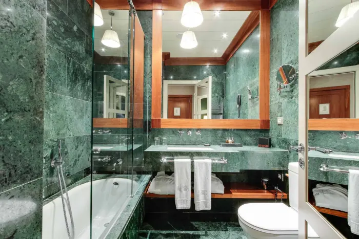 Es veu un bany amb banyera, lavabo doble i mirall amb il·luminació integrada.