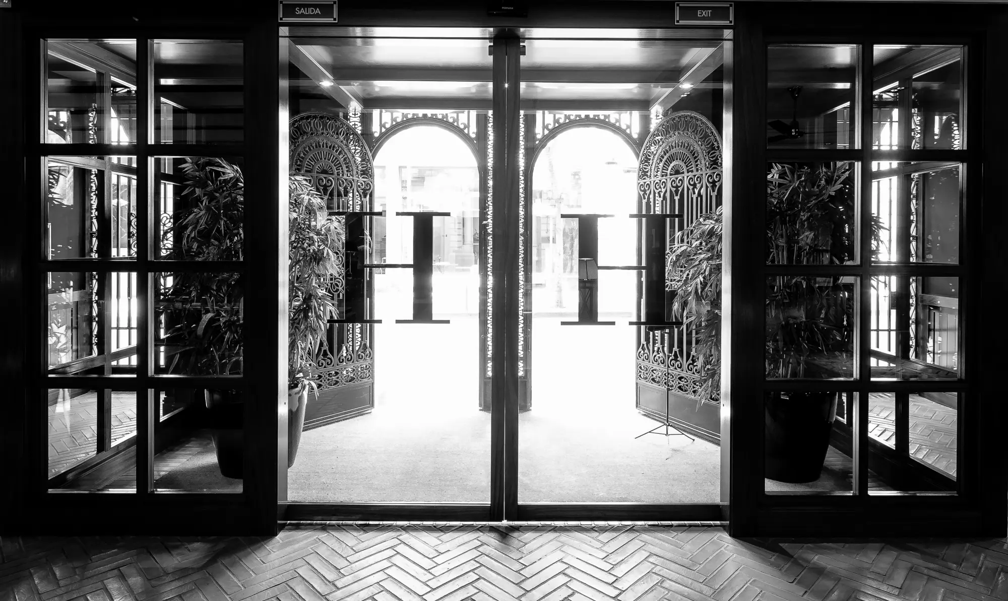 You can see the hotel entrance with open doors and a corridor with stone arches in the background.