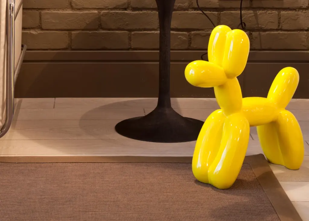 Si vede in un interno un palloncino giallo a forma di cane e un cartello di divieto.
