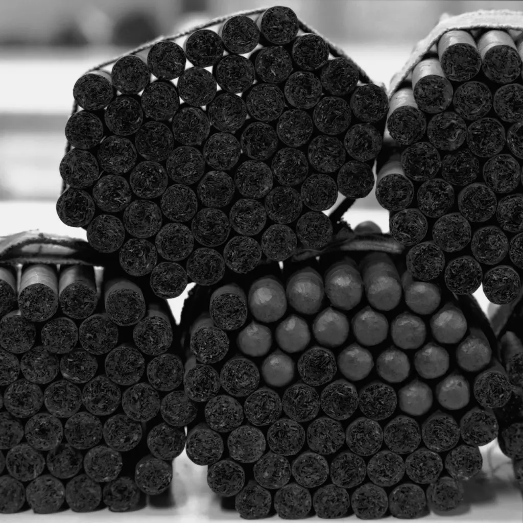 Se ven varios rollos de tabaco cilíndricos apilados en filas.