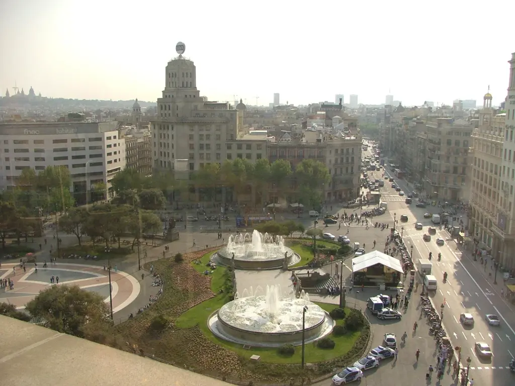 Vista panoramica della piazza con una fontana circolare e gli edifici tutt'intorno.