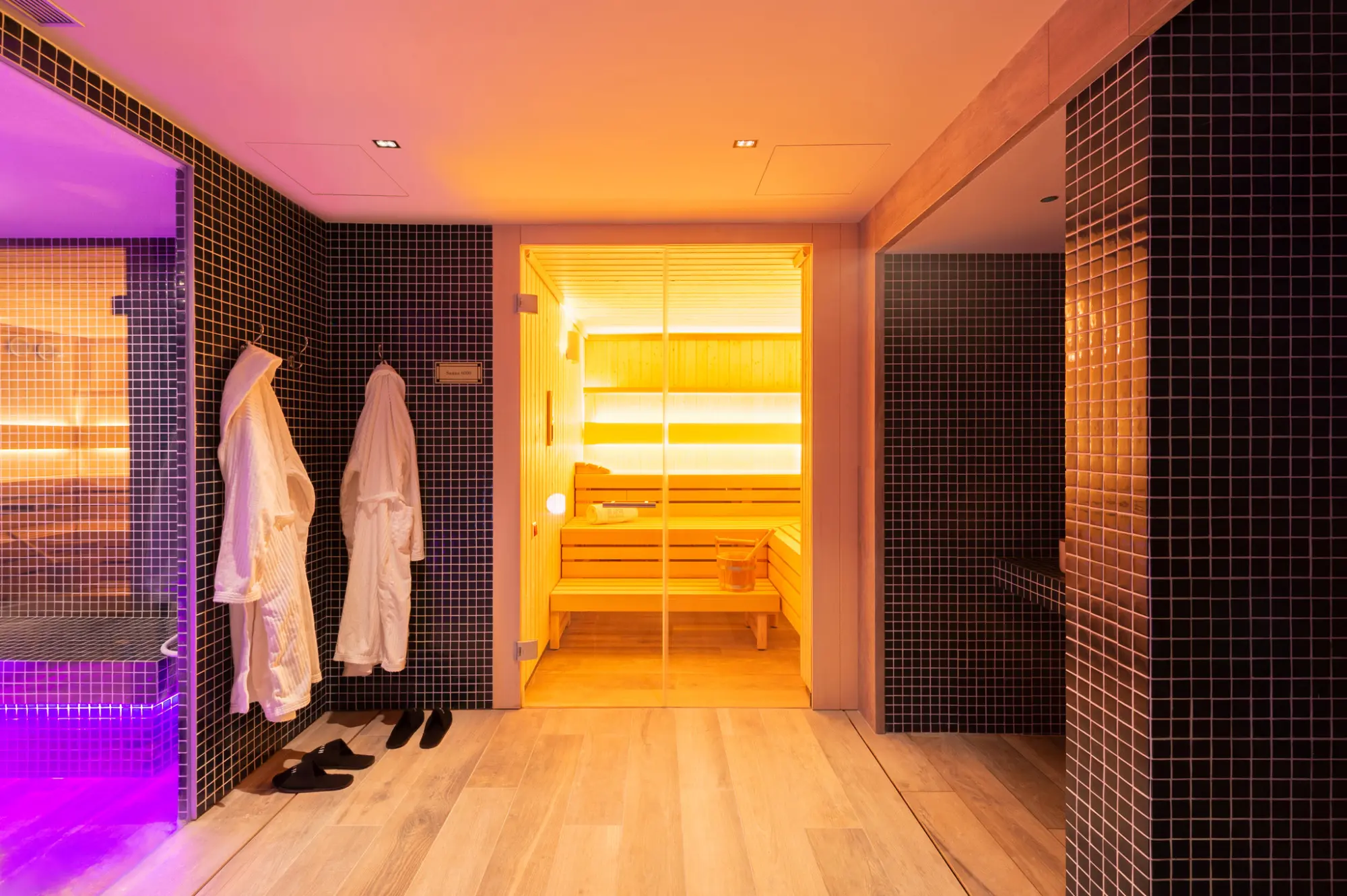 Ein Bild, das eine elegante und moderne Spa-Sauna zeigt, mit einer entspannenden Atmosphäre und minimalistischem Dekor. Sanfte Beleuchtung und Details in neutralen Tönen schaffen einen einladenden Raum für Wohlbefinden.