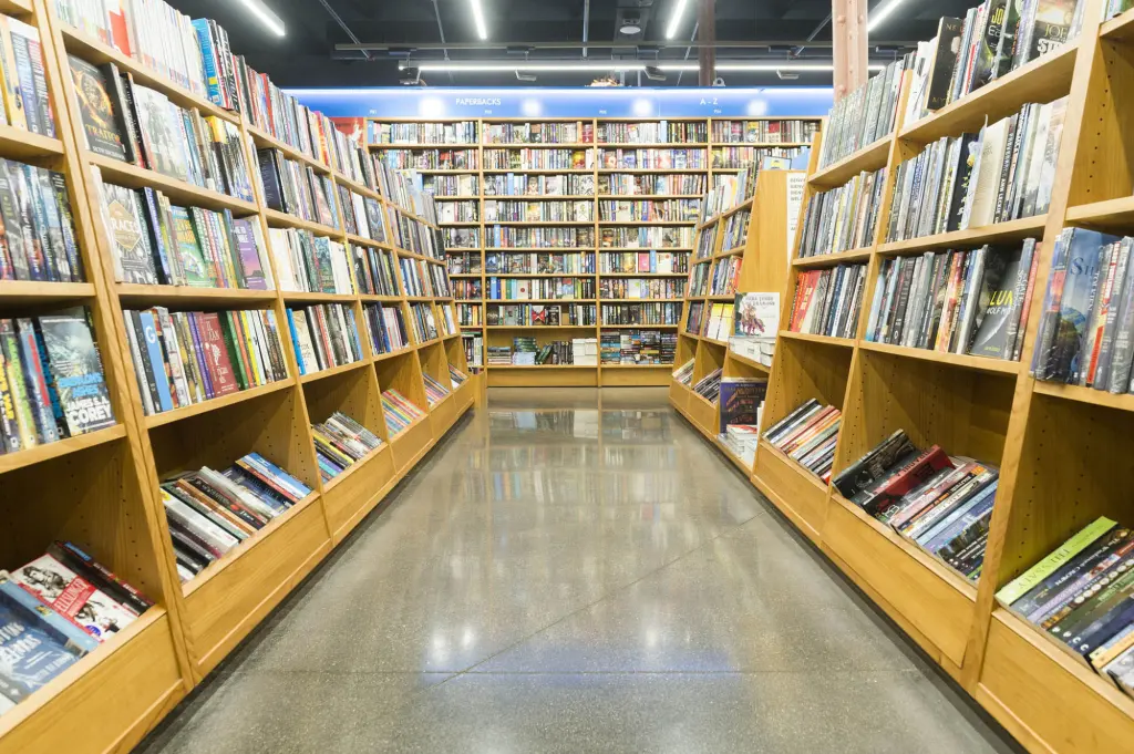 Se ve un pasillo con estanterías de libros de madera a ambos lados y suelo de baldosas.