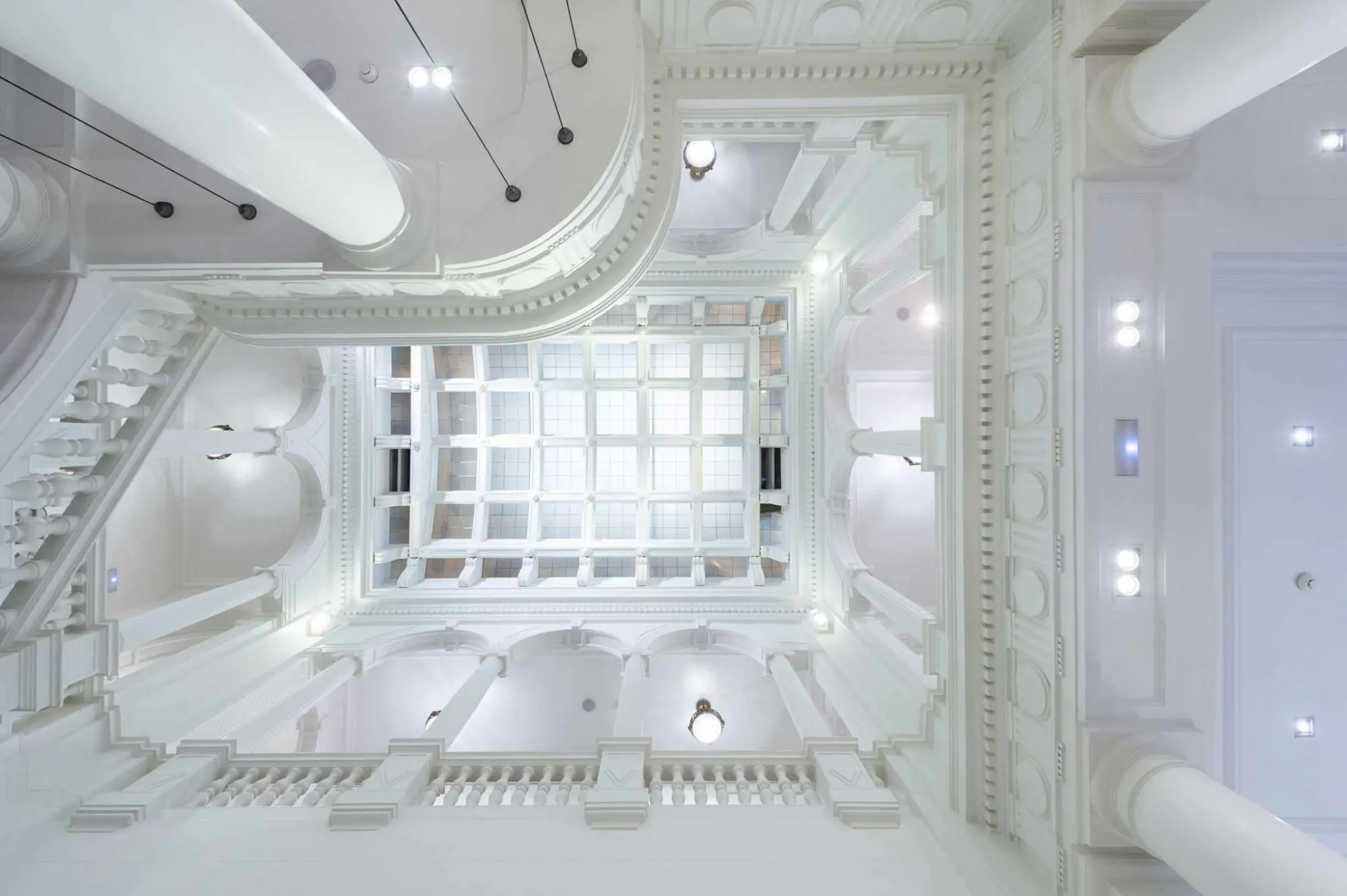 Se ve un espacio interior luminoso con arcos decorativos y techos con iluminación empotrada.