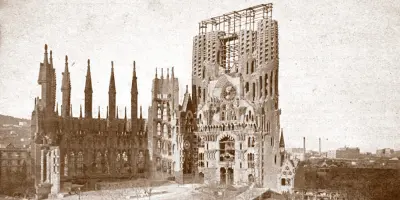La façana i les torres de la Sagrada Família s'alcen sobre la ciutat sota un cel parcialment ennuvolat.