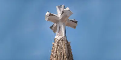 Se ve una gran cruz de piedra sobre el cielo azul.
