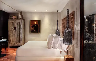 Habitación elegante y moderna con mobiliario de colores neutros y detalles decorativos que crean un ambiente cómodo y sofisticado.