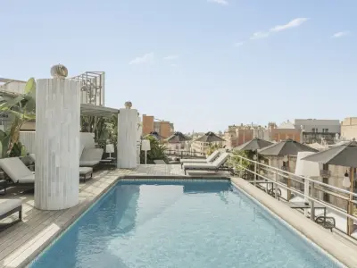 Una piscina moderna y elegante con agua azul clara, rodeada de un entorno relajante que invita al descanso y la diversión.