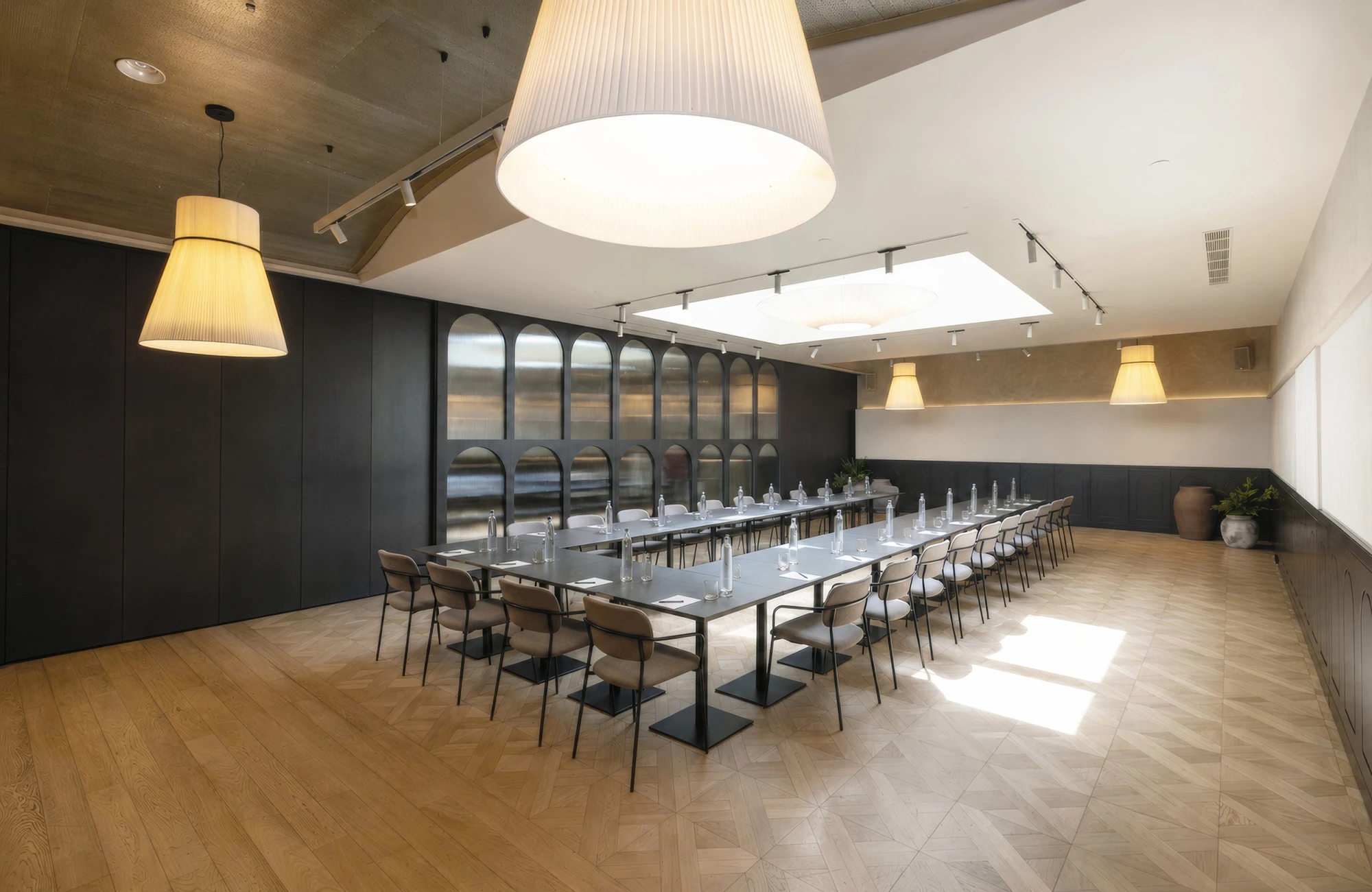 La imagen muestra una sala de reuniones con una mesa larga y sillas alrededor.