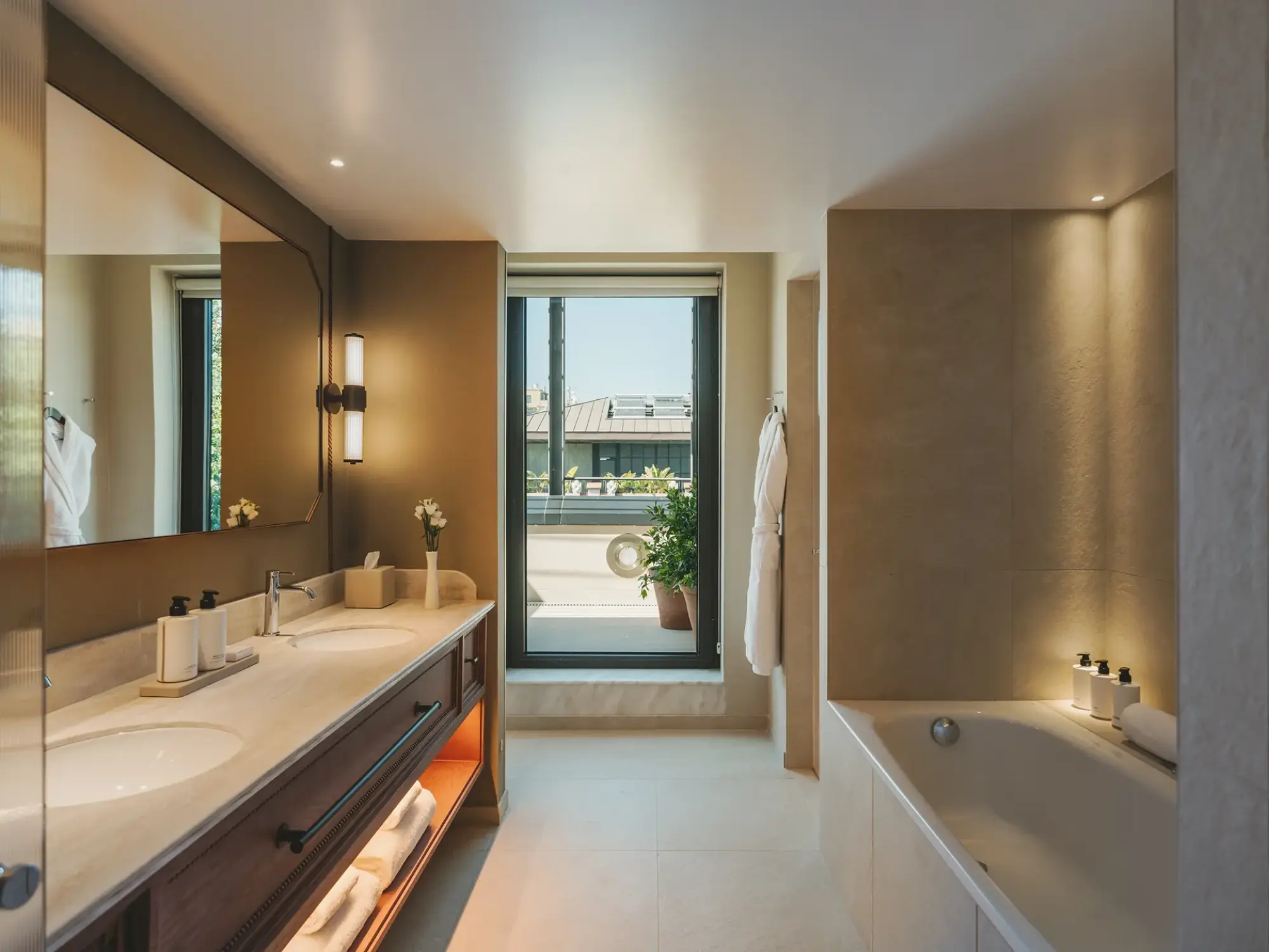 Se ve un baño con lavabo doble, bañera y una ventana con luz natural.